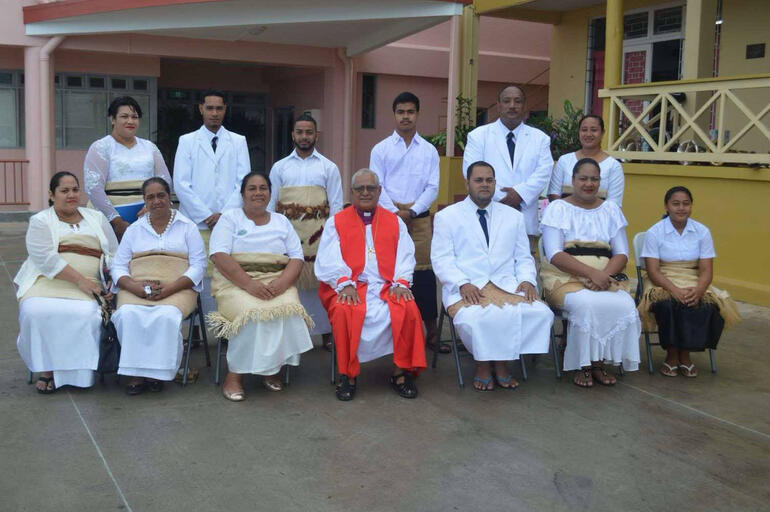 Bishop 'Afa lines up for a photo with staff from St Andrew's Anglican High School in Nuku'alofa.
